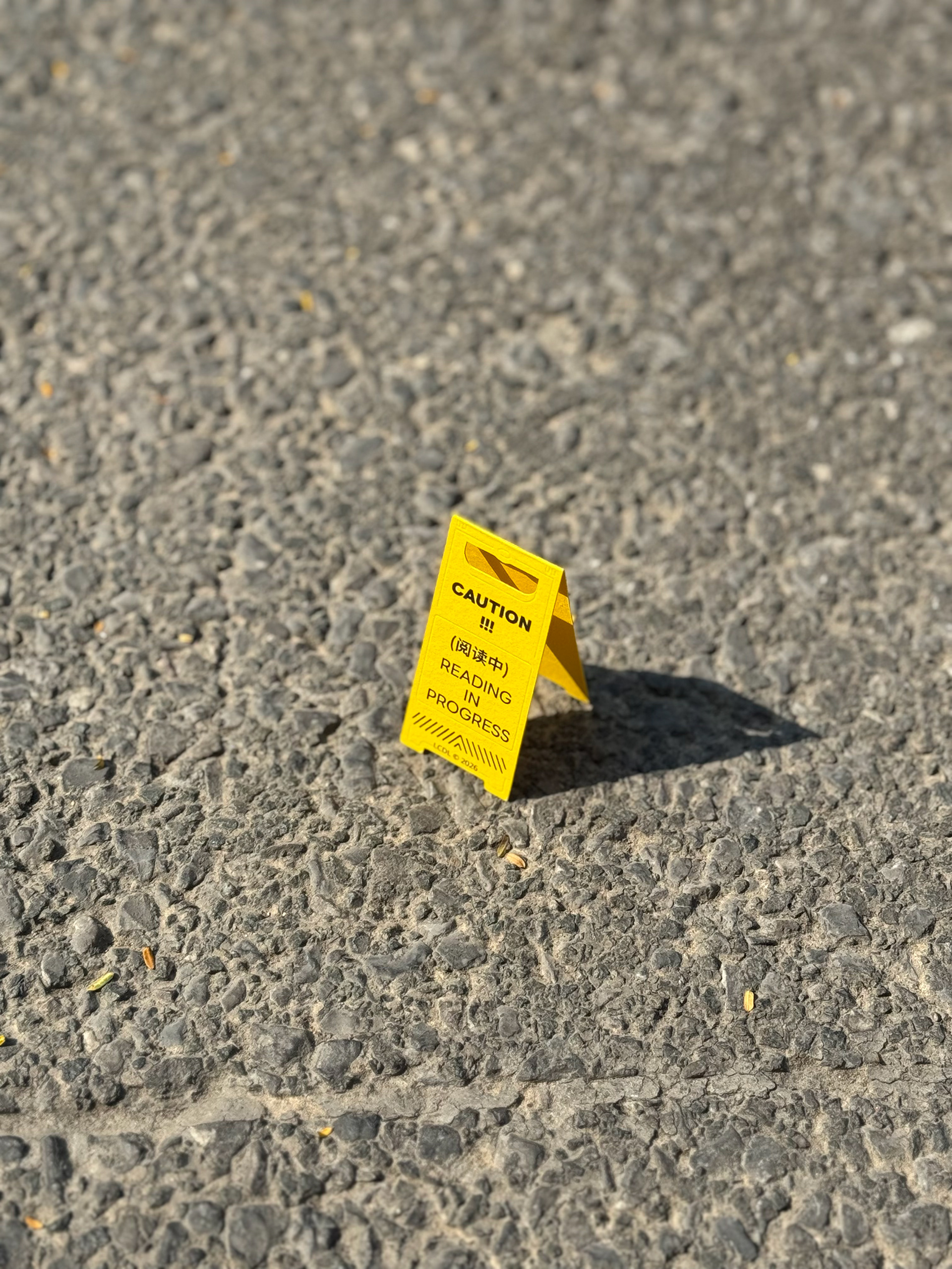 黃色 CAUTION 書籤立於粗糙地面上。